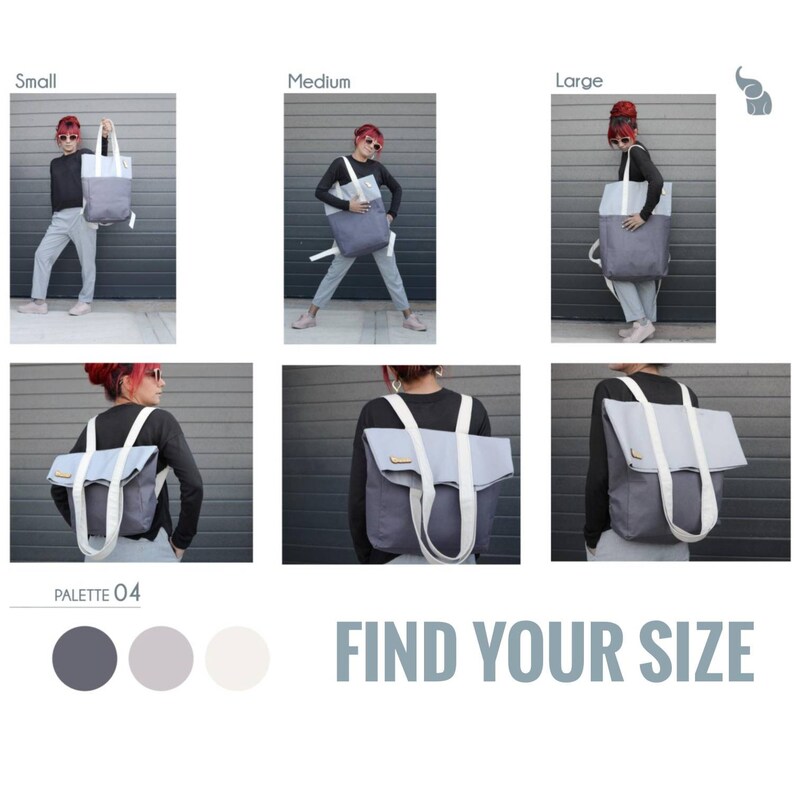 Op de afbeelding: Een grijze en witte canvas tote bag met een witte band. De tas wordt getoond in drie maten: klein, medium en groot. De tekst "FIND YOUR SIZE" wordt onder de afbeeldingen weergegeven. De tas kan als rugzak of als tote bag worden gedragen.
