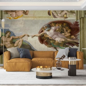 Op de afbeelding: Een woonkamer met een bruine hoekbank en twee ronde salontafels. De muur achter de bank heeft een grote muurschildering die een scène uit de Schepping van Adam voorstelt, een beroemd schilderij van Michelangelo.