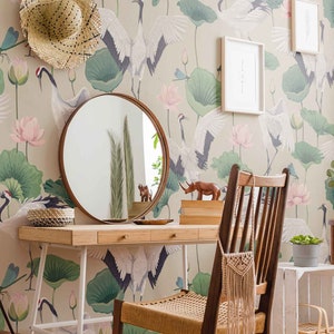May include: A vanity table with a round mirror, a wooden chair, and a white stool. The wall behind the table is covered in wallpaper with a pattern of cranes and lotus flowers.