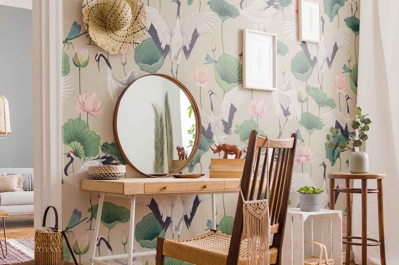 May include: A vanity table with a round mirror, a wooden chair, and a white stool. The wall behind the table is covered in wallpaper with a pattern of cranes and lotus flowers.