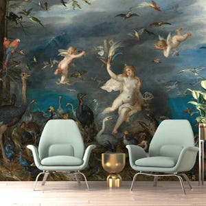 May include: A large wall mural featuring a classical painting with angels, birds, and a nude woman. Two light blue armchairs with metal legs are in front of the mural. A gold-colored side table and a plant in a gold pot complete the scene.