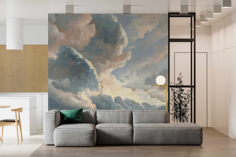 May include: A gray sectional sofa with a green throw pillow in front of a wall mural depicting a cloudy sky with shades of blue, pink, and white.