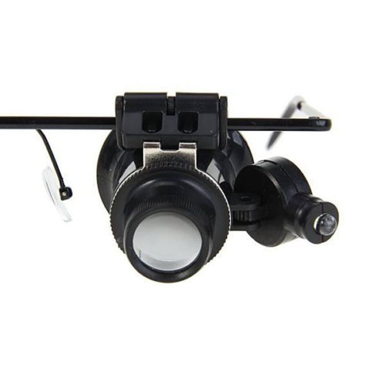 K&ouml;nnte beinhalten: Eine schwarze Lupe mit integriertem LED-Licht, befestigt an einem Kopfband. Die Lupe hat eine klare Linse und einen schwarzen Kunststoffrahmen.