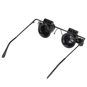 K&ouml;nnte beinhalten: Schwarze Lupenbrille mit verstellbaren B&uuml;geln. Die Brille hat zwei runde Linsen mit schwarzen Rahmen.