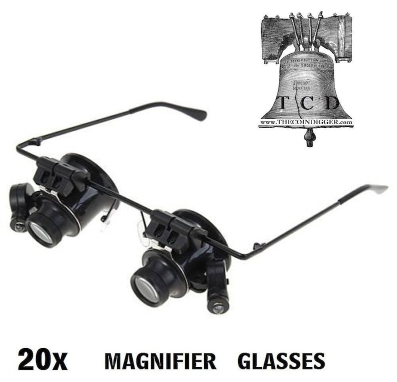 K&ouml;nnte beinhalten: Schwarze Lupenbrille mit verstellbaren B&uuml;geln und zwei Linsen. Die Brille ist mit "20x Magnifier Glasses" beschriftet.