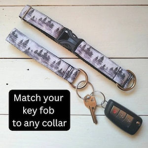 May include: A white and black patterned key fob with a silver key ring and a black car key. The key fob is attached to a matching white and black patterned dog collar. The text "Match your key fob to any collar" is written in black on a white background.