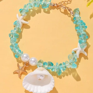 May include: A beaded bracelet featuring translucent light blue irregular stones, two white starfish charms, two white round beads, a gold-toned metal starfish charm, and a white seashell charm containing a single white pearl, with a gold-toned chain.