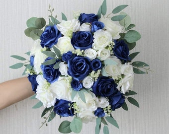 May include: A bridal bouquet with white and navy blue roses and greenery.