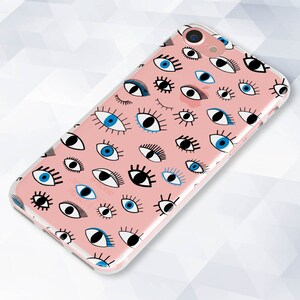 May include: A pink phone case with a pattern of blue and black eyes. The case is clear and shows the phone's camera lens.