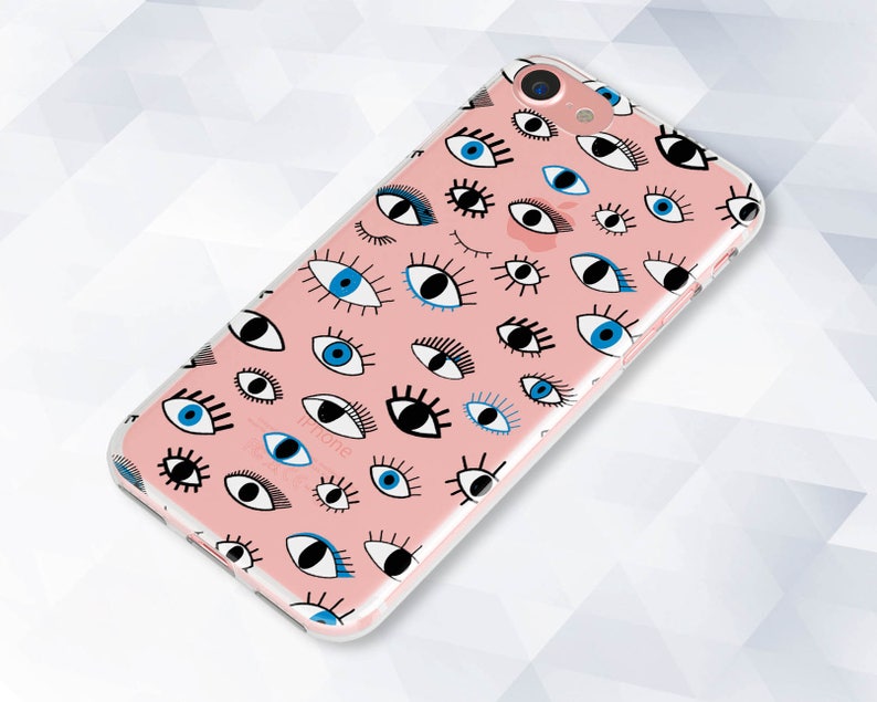 May include: A pink phone case with a pattern of blue and black eyes. The case is clear and shows the phone's camera lens.