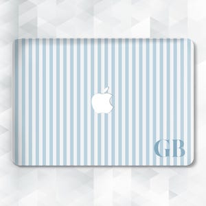 May include: A laptop skin featuring a light blue and white striped pattern. The Apple logo is centered, with the initials "GB" in the lower right corner. The design is a modern and minimalist style.