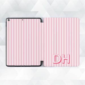 May include: A tablet case featuring a pink and white striped design, with the initials "DH" in pink. The case is open, showing the tablet screen and the interior. The design is a vertical stripe pattern.