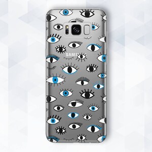 May include: A clear phone case with a pattern of blue and black eyes. The case is designed for a Samsung phone and has a cutout for the camera lens.