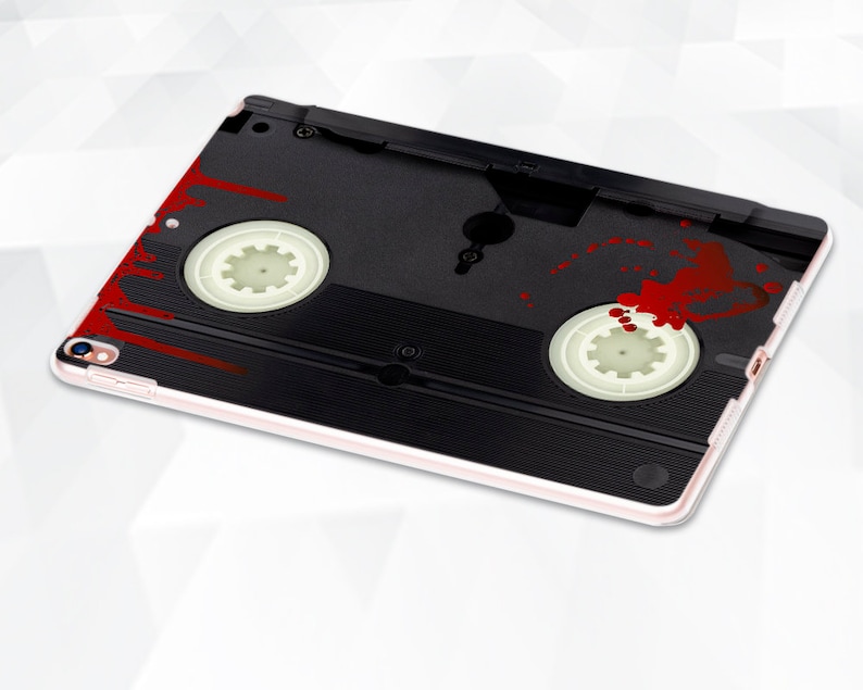May include: A black and white VHS cassette tape case with red blood splatter. The case is designed for an iPad.