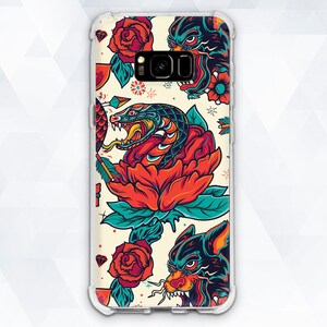 May include: A clear phone case with a colorful tattoo-style design featuring a snake, roses, and wolves. The design is vibrant and detailed, with a white background.