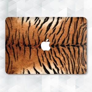 May include: A laptop skin with a tiger print design. The skin is brown, orange, and black with a white Apple logo in the center.