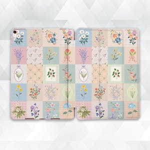 May include: An open tablet case featuring a patchwork design with floral illustrations. The case is divided into squares, each showcasing a different flower arrangement in pastel colors like pink, blue, and yellow. The overall aesthetic is vintage and feminine.