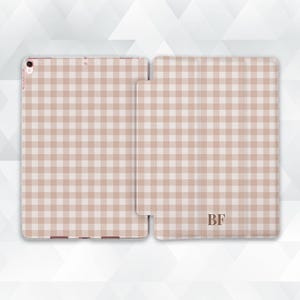 May include: A light brown and white gingham pattern iPad case and cover. The case is open, revealing the iPad, and the cover is next to it. The initials "BF" are printed on the cover.