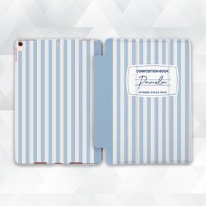 May include: A light blue and white striped tablet case, open to display the interior. The case features a composition book design with the name "Pamela" and the text "512 pages / 9.74 in x 7.02 in".