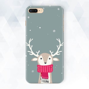 May include: A gray phone case with a white snowflake design and a cartoon reindeer wearing a red scarf. The reindeer has brown antlers and a light brown face.