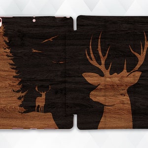 May include: A black and brown wood-grain patterned iPad case with a silhouette of a deer and a forest scene on the left side and a silhouette of a deer with antlers on the right side.