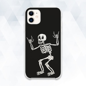 Puede incluir: Carcasa de teléfono negra con una ilustración de esqueleto blanco. El esqueleto está en una pose de rock and roll con los brazos levantados y las piernas separadas.