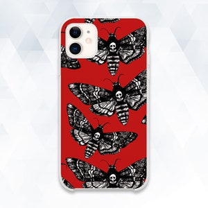 Puede incluir: Una funda de teléfono roja con un patrón en blanco y negro de polillas con calaveras en sus cuerpos. La funda está diseñada para un iPhone.