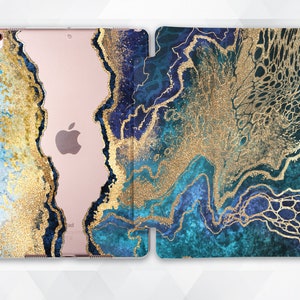 May include: An iPad case with a blue and gold marble design, featuring a clear back. The case has a gold glitter effect and an abstract pattern in shades of blue and gold.