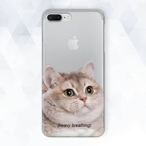 Peut inclure: Une coque de téléphone transparente avec une image d'un chat gris et blanc avec le texte "(heavy breathing)" imprimé en bas.
