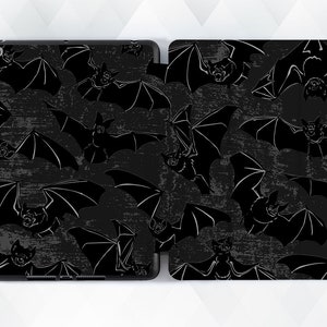 May include: Black and white iPad case with a repeating pattern of bats on a dark grey background.