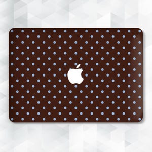 May include: A brown laptop cover with a pattern of light blue polka dots. The cover features a white Apple logo in the center. The design is a simple, yet stylish accessory for a laptop.