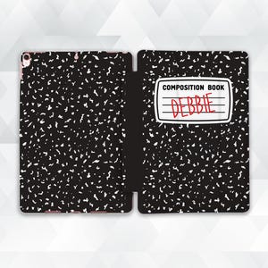 May include: Black and white composition notebook iPad case with the words "Composition Book" and "Debbie" written on the front.