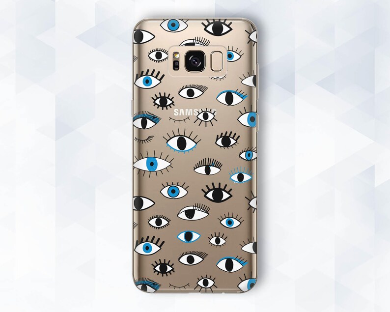 May include: A gold phone case with a pattern of blue and black eyes. The case has a Samsung logo on the back.