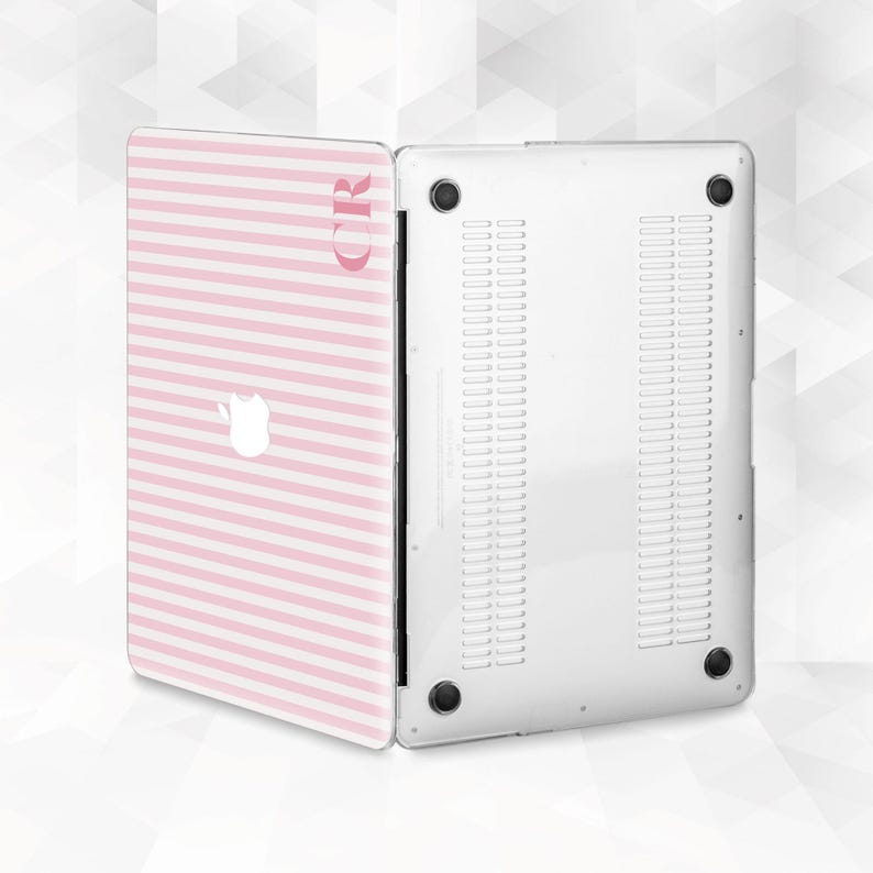 May include: A pink and white striped laptop case with the initials "CR" in a matching pink font. The case is open, revealing the white underside of the laptop. The Apple logo is visible on the case.