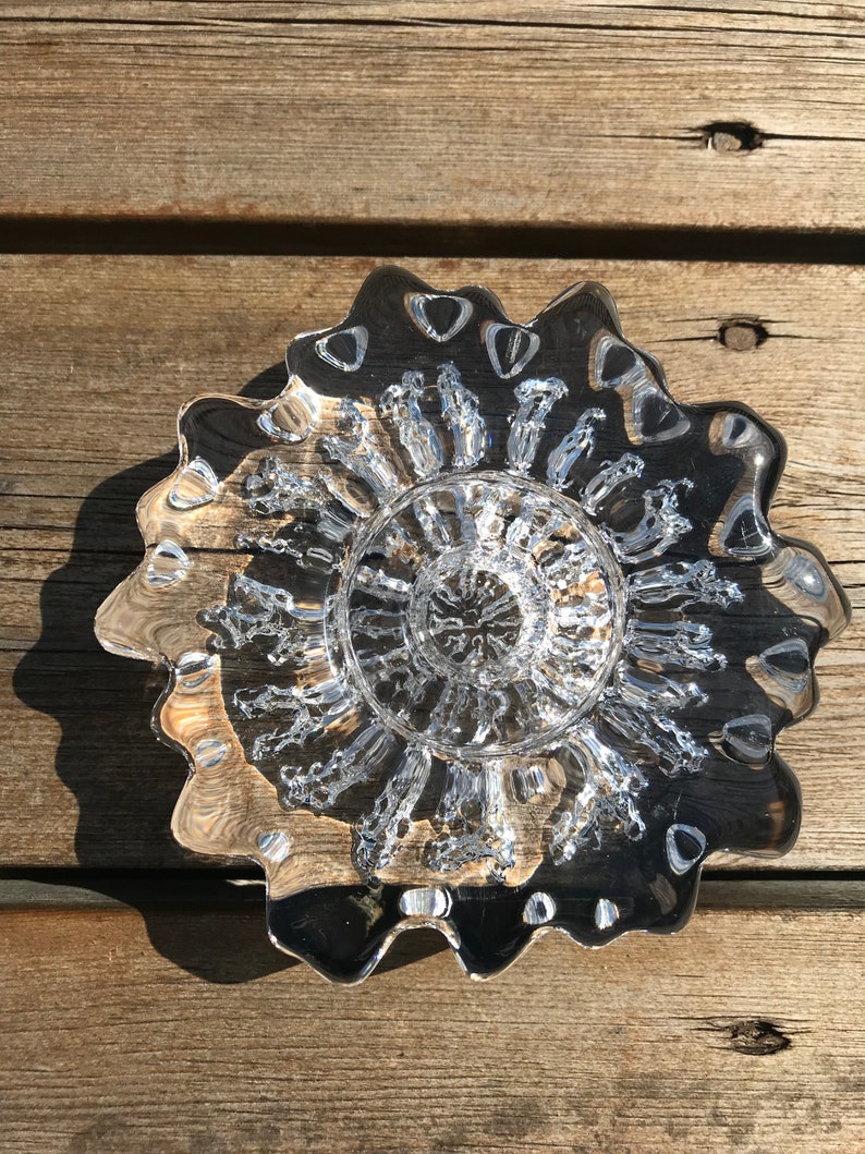 Pu&ograve; includere: Una ciotola di vetro trasparente con un bordo ondulato e un design testurizzato a bolle. La ciotola &egrave; vuota e sembra essere fatta a mano.