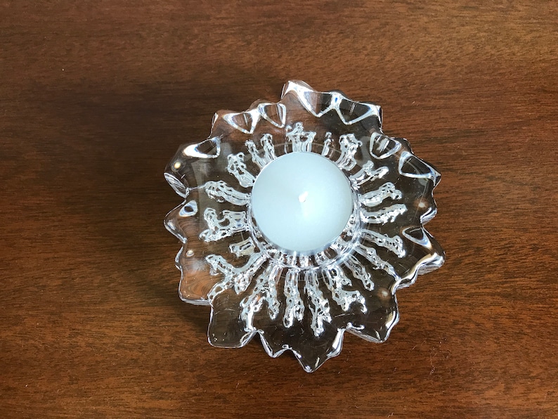 Pu&ograve; includere: Un portacandele in vetro trasparente con un design a forma di stella. Il portacandele ha una piccola rientranza rotonda al centro per una candela tea light.