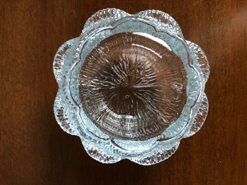 May include: A clear glass bowl with a scalloped edge and a textured surface. The bowl is round and has a diameter of approximately 10 inches.