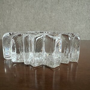 Pu&ograve; includere: Un piatto di vetro trasparente a forma di stella con una superficie testurizzata. Il piatto &egrave; fatto di vetro spesso e ha un design unico e moderno.