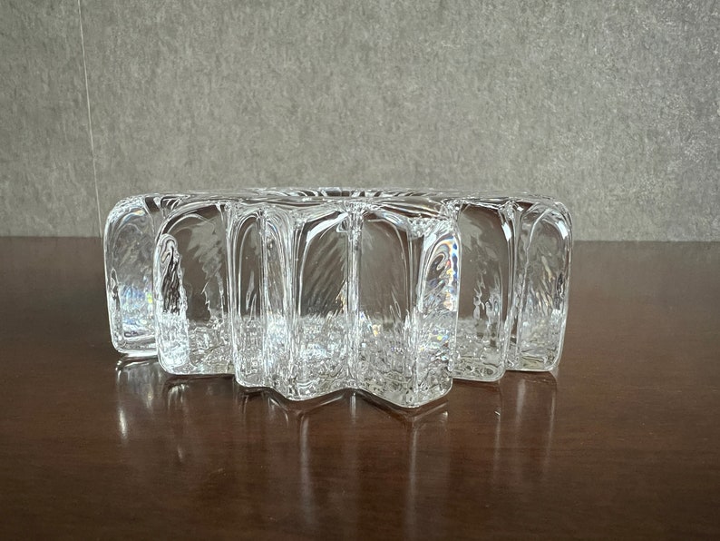 Pu&ograve; includere: Un piatto di vetro trasparente a forma di stella con una superficie testurizzata. Il piatto &egrave; fatto di vetro spesso e ha un design unico e moderno.