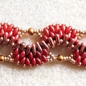 Puede incluir: Un brazalete de cuentas rojas y doradas con cierre de palanca y un dije en forma de corazón.