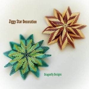 May include: Two beaded star ornaments, one in teal and gold and one in brown and gold. The teal and gold star is on the left and the brown and gold star is on the right. The text "Ziggy Star Decoration" is at the top of the image and the text "Dragonfly Designs" is at the bottom of the image.