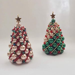 May include: Two beaded Christmas trees, one in pink and green with red accents, and the other in green with red and gold accents.