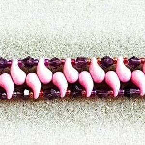 May include: A pink and purple beaded bracelet with a heart-shaped clasp. The bracelet is made with small, teardrop-shaped beads and features a repeating pattern of pink and purple beads. The bracelet is approximately 7 inches long.
