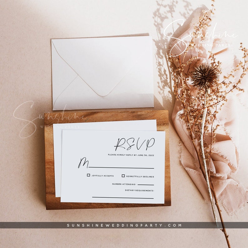 May include: A white RSVP card with black text. The card has a section for the guest to indicate if they will be attending the wedding, the number of guests attending, and any dietary requirements. The text on the card reads "RSVP, Please kindly reply by June 30, 2022, Joyfully Accepts, Regretfully Declines, Number Attending, Dietary Requirements".