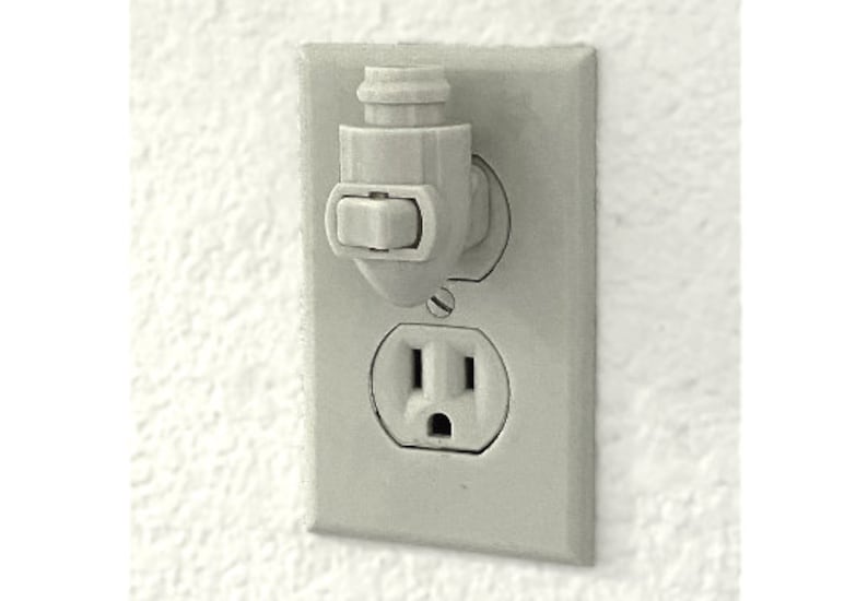 Op de afbeelding: Een wit stopcontact met een witte kunststof veiligheidsafdekking. Het stopcontact heeft een standaardconfiguratie met drie pennen.