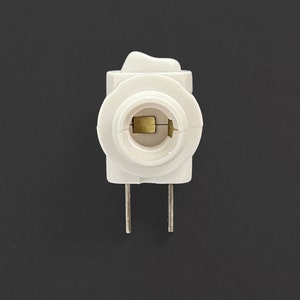 Op de afbeelding: Witte plastic lampfitting adapter met een ingebouwde aan/uit-schakelaar en twee pinnen.