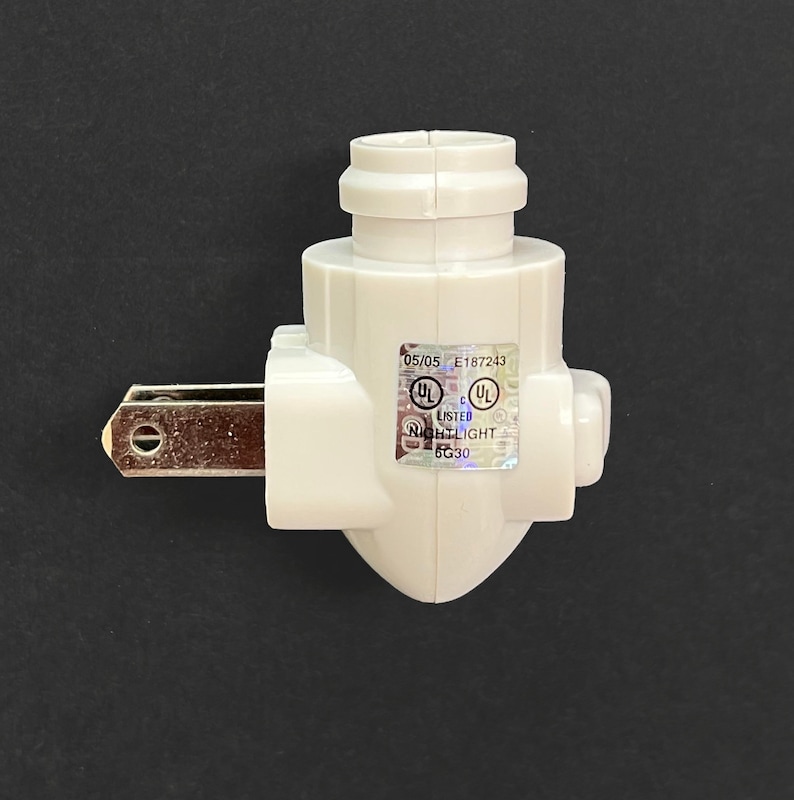 Op de afbeelding: Witte plastic stekker voor een nachtlampje met een standaard Nederlandse stekker en een ronde fitting voor een lamp. De stekker heeft een UL-gecertificeerd label met het nummer E187243.