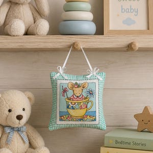 May include: A nursery scene with a plush bunny and teddy bear. A framed print reads "sweet baby." A decorative pillow features a mouse in a teacup design. Stacking rings and books with titles like "Bedtime Stories" complete the scene.