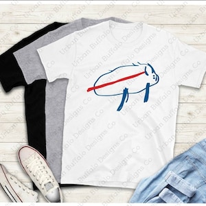May include: Two t-shirts with a blue and red drawing of a pig on the front. The text "Urban Buffalo Designs Co" is repeated on the shirts.