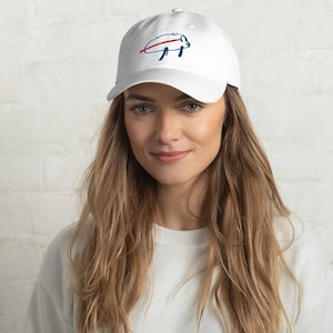 May include: White baseball cap with an embroidered blue buffalo silhouette and red stripe across the middle. The buffalo is facing left.